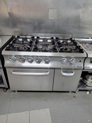 une cuisinière et un four dans une cuisine remplie de casseroles et de poêles