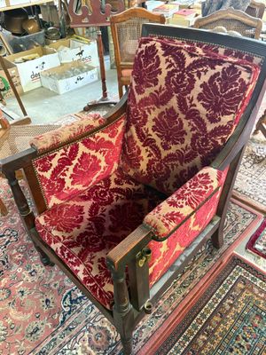 a red and gold chair in a room with a rug on the floor