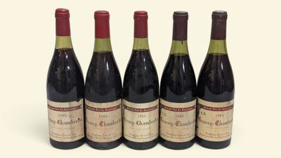 quatre bouteilles de vin sont alignées sur une surface blanche