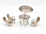 three chairs and a table with an umbrella on it