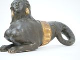 a statue of a lion laying down on a white surface