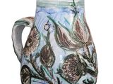 a white vase with a blue and green design on it