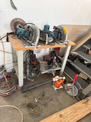 de nombreux outils qui traînent sur une table dans le garage