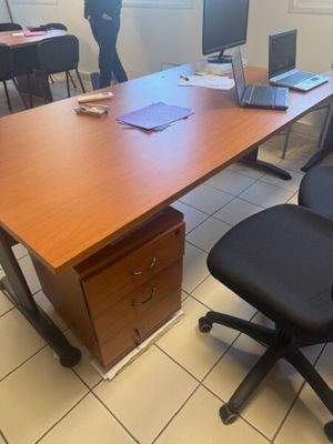 tables and chairs in a room with a man standing in the background