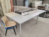 a white table with a blue chair next to a stack of books