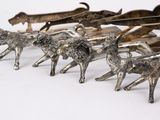 a group of silver figurines of animals on a white surface