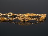 a close up of a gold bracelet on a black surface