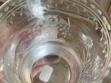 someone is holding a glass with water in it on a table
