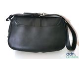 the small black bag is sitting on a white surface