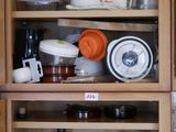de nombreuses bouteilles et de nombreux plats sur les étagères de la cuisine