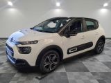 une citrole blanche garee sur un plancher en damier dans un garage