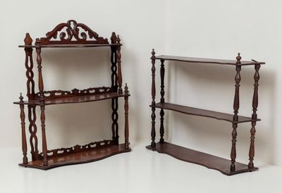 une paire d'étagères anciennes en bois exposées devant un mur blanc