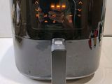 philips air fryer on a white counter top with a person taking a picture of it