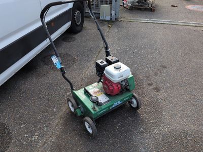 a small lawn mower that is sitting in the parking lot
