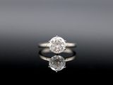a close up of a diamond ring on a reflective surface