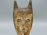 une image d'un masque en bois sur un support