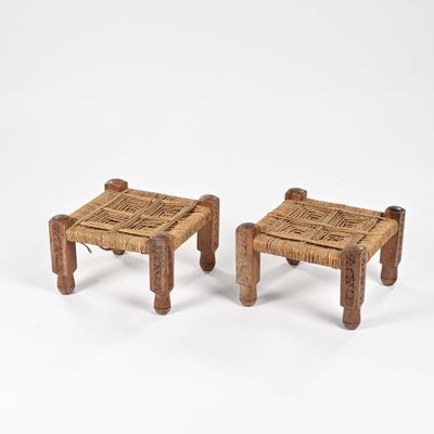 deux petits tabourets en bois avec des assises tressées, posés sur une surface blanche