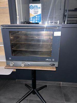 a toaster oven sitting on top of a stand in a kitchen