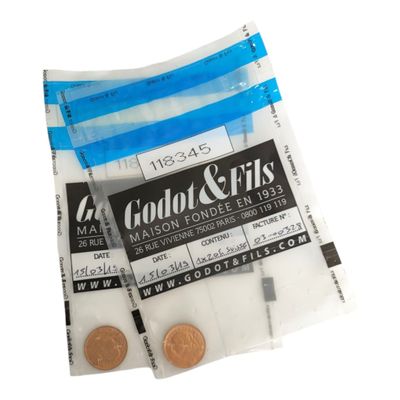 un gros plan sur un sachet de pièces et une pièce sur fond blanc