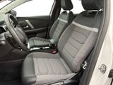 the interior of a car with a grey seat cover and a black steering wheel