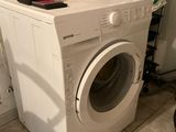 une machine à laver sur laquelle est posé un sac