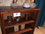 a shelf that has a bunch of vases on it