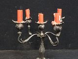a silver candelab with orange candles on it