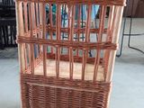 une chaise en osier à roulettes qui se trouve dans une pièce
