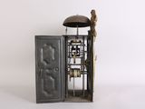 a small metal clock with a bell on top of it