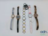 quatre montres différentes sont alignées sur une surface blanche