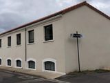 un bâtiment blanc avec une cheminée en briques sur le côté
