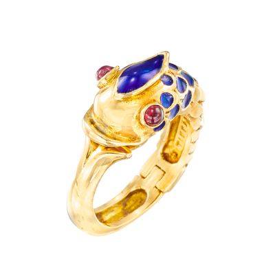 un gros plan d'une bague en or sertie de pierres bleues et rouges