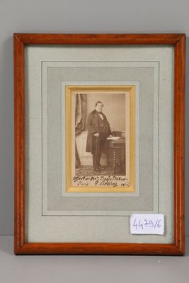 une vieille photo d'un homme assis à un bureau dans une pièce