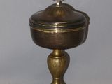 a small metal bowl with a lid sitting on a table