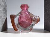 a pink glass bottle sitting on a shelf next to a block