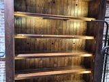 une bibliothèque en bois avec une étagère métallique en dessous