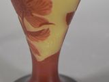 a glass vase with a red and yellow design on it