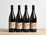 three bottles of wine sitting on top of a wooden table