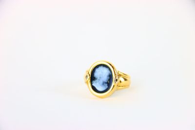 une bague en or avec une pierre bleue au centre