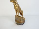 statue d'un chien posé sur un rocher, sur fond blanc