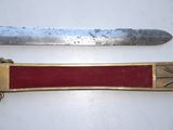 pair of old knives on a white surface with a red handle