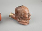 a pipe with a man ' s face on it next to a pipe with a man ' s face on it