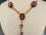 Le collier est composé d'or et de pierres violettes.