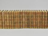 a large collection of old books on a white surface