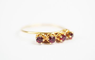 a close up of a gold ring with three ruby stones