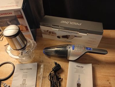 Quelqu'un utilise un aspirateur sans fil pour nettoyer une table en bois.