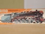 un petit train posé sur une table à côté d'une boîte
