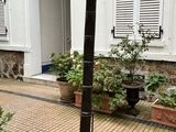 un poteau noir devant un immeuble orné de plantes en pot