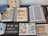 beaucoup de timbres posés sur une table, à côté d'un livre