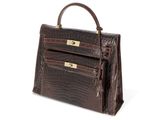 an image of a brown crocodile skin handbag on a white background
